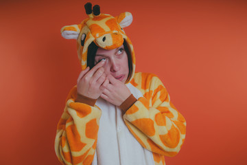 pajamas in the form of a giraffe. emotional portrait of a girl on an orange background. crazy and funny man in a suit. animator for children's parties