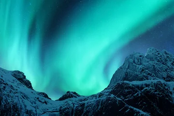 Foto auf Alu-Dibond Aurora borealis über dem schneebedeckten Berggipfel auf den Lofoten, Norwegen. Nordlichter im Winter. Nachtlandschaft mit Polarlichtern, schneebedeckten Felsen. Sternenhimmel mit Aurora. Natur Hintergrund © den-belitsky