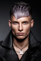 Young man with purple hair and creative makeup and hair.