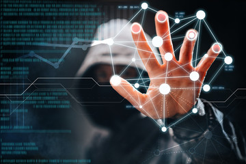 Cyber crime. Male hacker accessing to personal information. Hooded man with obscured face touching digital panel with mixed media and binary code. Virtual crime, cybersecurity concept.