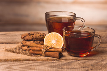 two cups with tea, cookies, cinnamon and lemon 