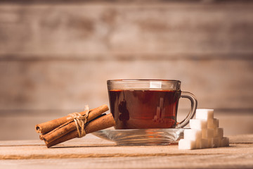 a cup with tea, sugar and cinnamon  