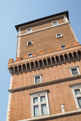 Fototapeta na wymiar Roman architecture, tower with orange mediterranean facade and windows