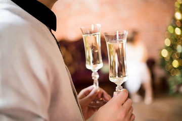 Two glasses with sparkling wine in male hands