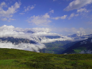 prato verde con vista su montagne e cielo nuvoloso