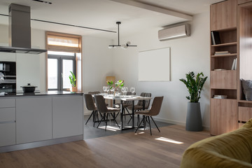 Sunny modern interior with white walls and kitchen zone