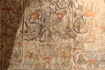Fototapeta na wymiar Some decorative frescoes with putti, mythical creatures and flowers on the walls of the Virgen del Castillo church in Monterde, Aragon region, Spain