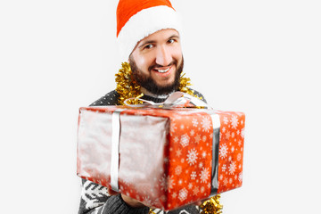 A man with a Christmas gift in his hands, in the Studio on a white background, gift close-up, gives a Christmas gift