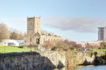 A landscape of the Avon river in front of the rumbled Saint Peter's Church in the Castle Park from the Bristol Bridge in the Bristol, United Kingdom