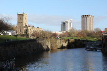 A landscape of the Avon river in front of the rumbled Saint Peter's Church in the Castle Park from the Bristol Bridge in the Bristol, United Kingdom