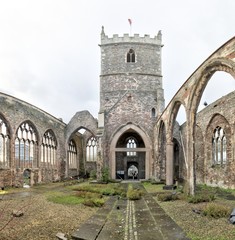 Fototapeta na wymiar The interior of the abandoned rumbled Saint Peter's Church in the Castle Park, with pointed arch windows and bell tower, in Bristol, United Kingdom