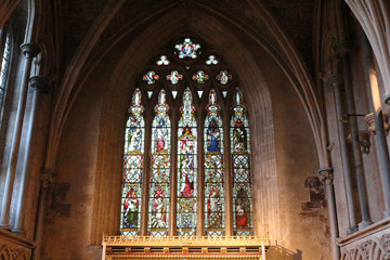 A pointed arch, stained glass window with Gothic decorations in the Bristol Cathedral, in United Kingdom