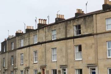 Beige terrace houses with sash hung windows and chimney stacks in a cloudy day in Bristol, United Kingdom
