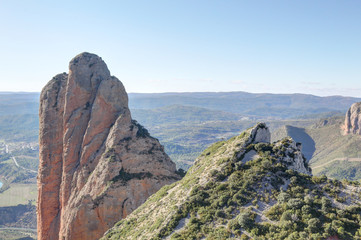 Fototapeta na wymiar The high Mallos de Riglos rock formations and mountains, popular for climbers and excursionists, in Aragon, Spain, during a sunny summer day