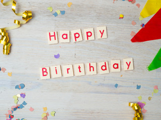 Happy Birthday Lettering with party decoration on wooden background