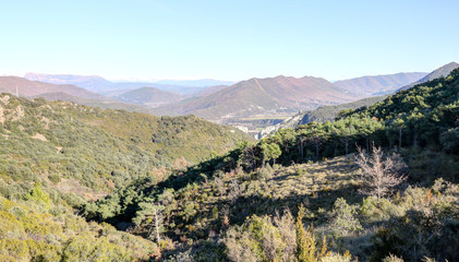 Obraz premium A landscape of the pre-Pyrenees lands and mountains, with fir and pine tree forests, on the way from Riglos to La Peña in winter, Aragon, Spain