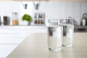 Glasses of fresh water on table indoors. Space for text