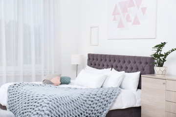 Stylish room interior with large comfortable bed