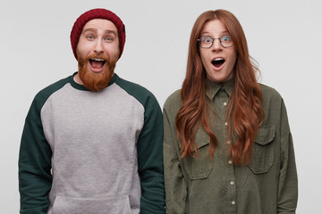 Family portrait of excited straight couple, keep mouth open widely, wears casualy, satisfied and...