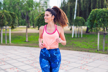 Young beautiful fit woman is running in the park. Healthy concept