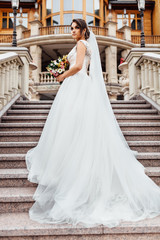 Obraz premium portrait of a beautiful bride on the steps, in a white dress