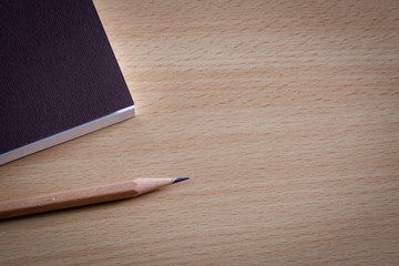 Book diary for gifts to give souvenirs and pencils placed on wooden table.