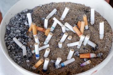 Many brands of cigarette butts are left in the ashtray.
