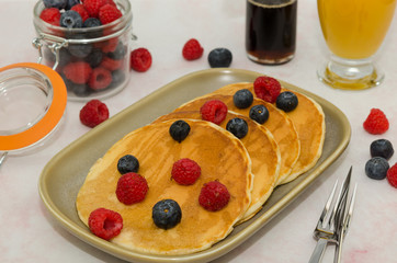 Delicious homemade pancakes with fresh blueberry and raspberry, maple syrup. Pancakes 
