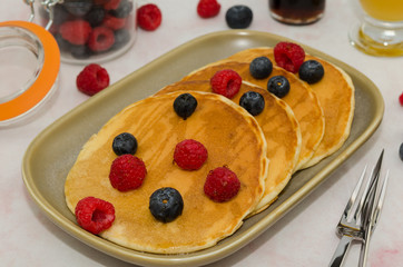 Delicious homemade pancakes with fresh blueberry and raspberry, maple syrup. Pancakes 