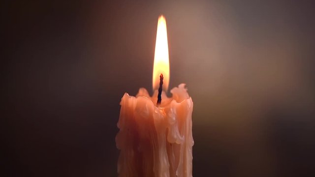 Candles flame blows out on a dark background. Candle light border design. Melted wax candle burning at night. Slow motion 4K UHD video footage. 3840X2160