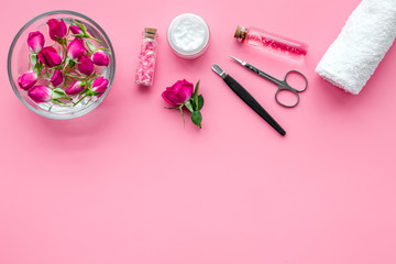 manicure equipment with spa salt and rose petals pink background top view space for text