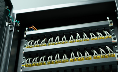 Network ethernet cables connect to switch server rack in data center hub of university, wires management on the interface panel