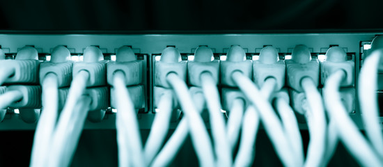 Network ethernet cables connect to switch server rack in data center hub of university, wires management on the interface panel