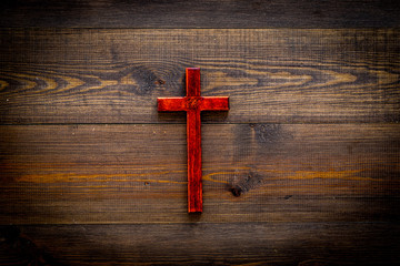 Funeral concept. Wooden cross on dark wooden background top view copy space