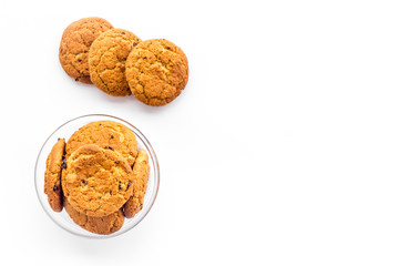 Homemade oatmeal cookies in glass bowl on white background top view copy space