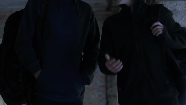 Cheerful friends walking home after school discussing mates and sport friendship