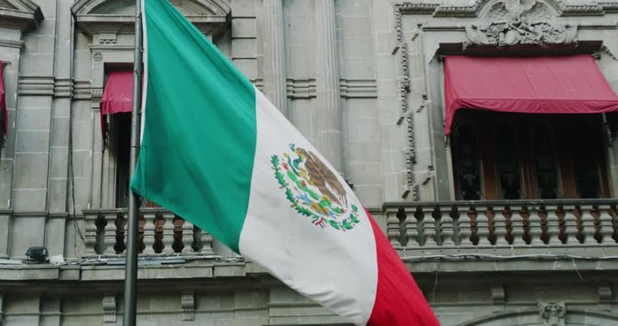 Mexican architecture and flag in slow motion at Zocalo de Puebla area.
