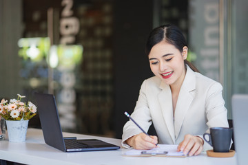 Young woman working at lap top in the office.