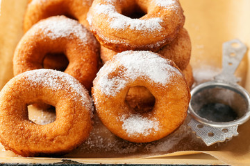 Homemade donuts  with powdered sugar on a wooden baclground