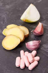 Ginger, onion, garlic and medical pills, choice between healthy nutrition and supplements