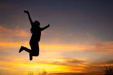 happiness, freedom, motion and people concept - smiling young woman jumping in air sunset background