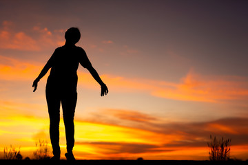 Young woman relaxing in winter sunset sky outdoor.