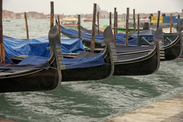 Fototapeta na wymiar Zugedeckte venetianische Gondel schauckeln bei Hochwasser in Venedig