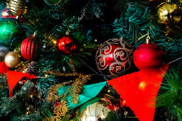 Magically decorated Christmas Tree with balls, ribbons and garlands on a blurred shiny, fairy and sparkling background.Decorated Christmas tree. Bright decorations for the New Year. Christmas