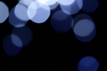 Abstract blue bokeh on dark background, Christmas blurred background.