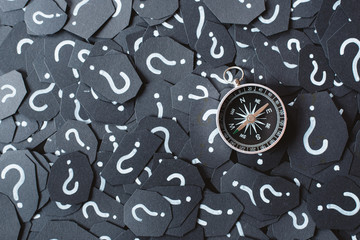 Metal compass on question mark background. Concept of travel, navigation, explore and where to go