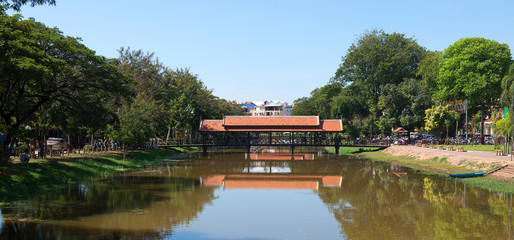 Obraz premium A bridge in Siem Reap with reflections in the river, Cambodia