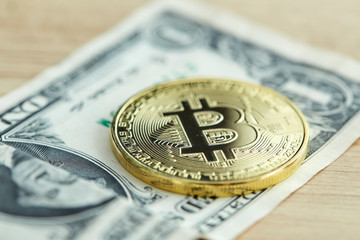 Golden Bitcoin coin on wood background