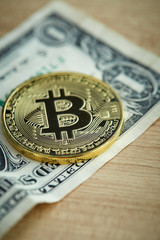Golden Bitcoin coin on wood background