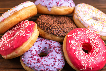 Assorted delicious donuts on rustic wooden background